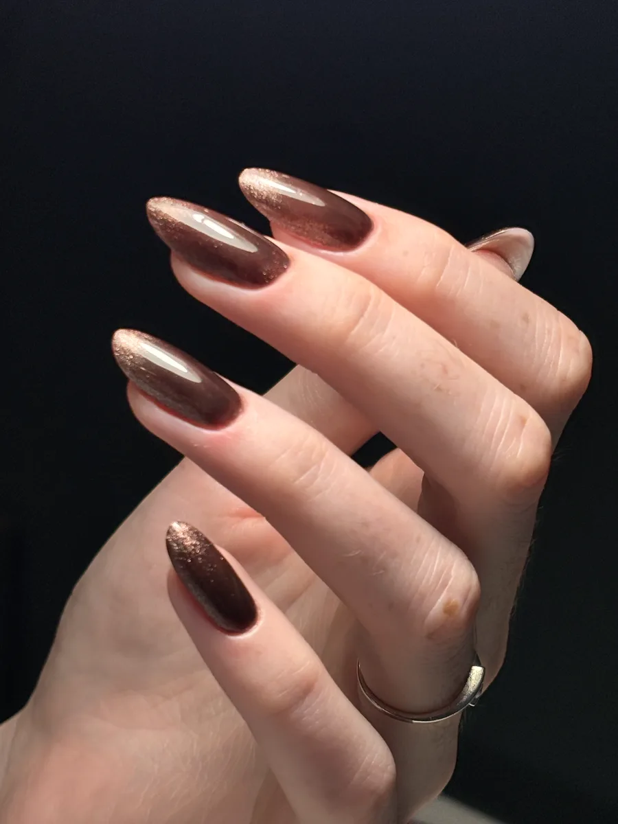 Pose gel brun chocolat aux reflets cuivrés sur ongles amande longs, réalisée à l'atelier